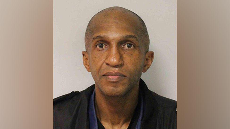 Anthony Marks wearing a dark shirt and jacket, looking directly into the camera