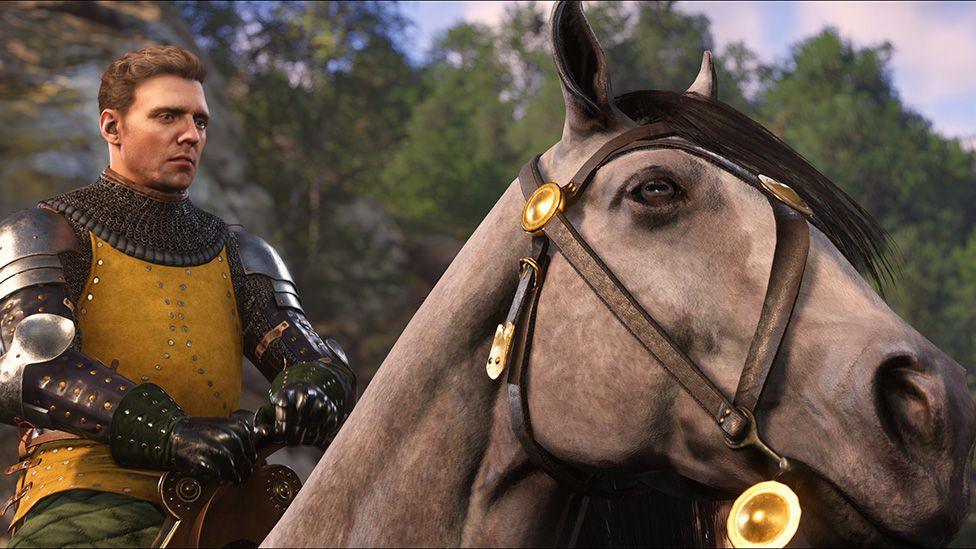 Screenshot shows Henry from Kingdom Come: Deliverance 2 wearing chainmail armour as he solemnly rides a horse through a forest.