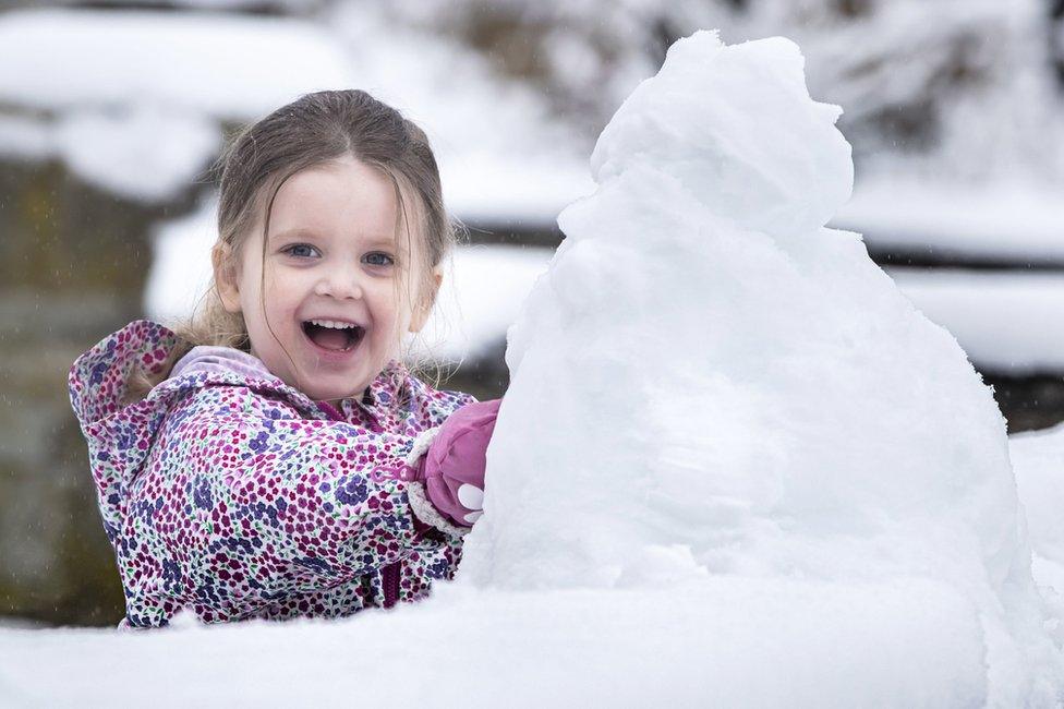 Three-year-old Molly plays in the snow