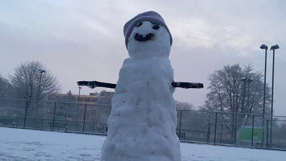 Large snowman wearing a hat.