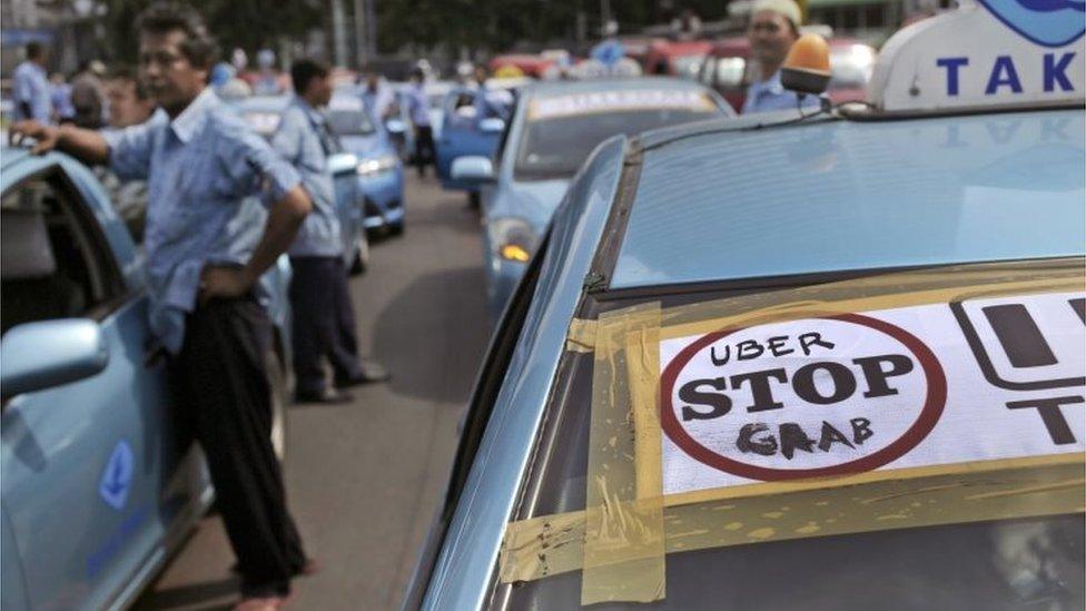 A taxi with a sign saying 'Top Uber/Grab' in Jakarta