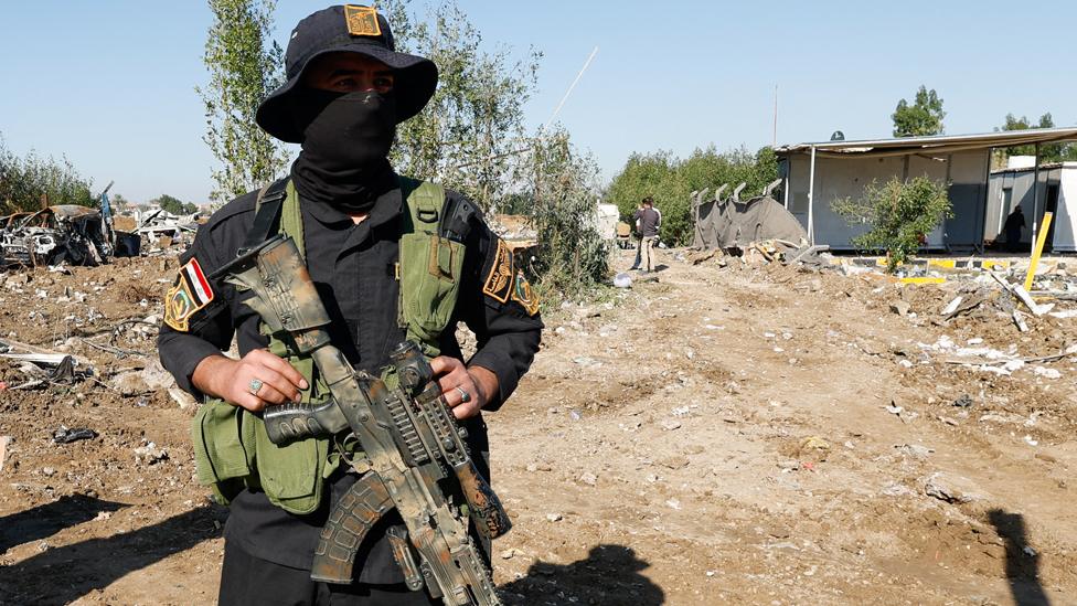 Fighter of the Iraqi Kataib Hezbollah militia group stands the site of a U.S. airstrike, in Hilla, Iraq December 26, 2023