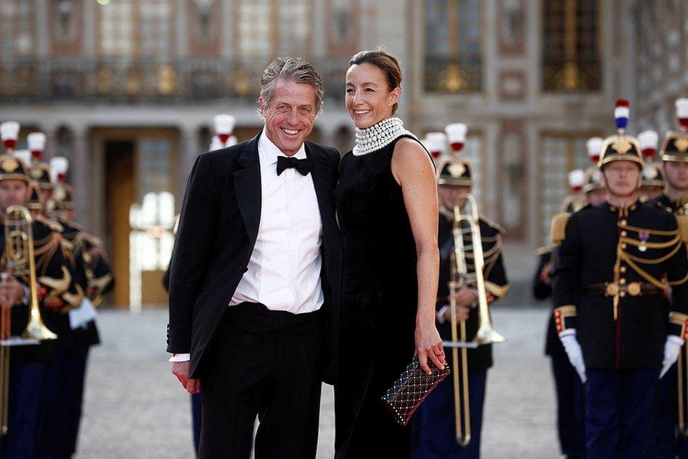 Hugh Grant and his wife Anna Elisabet Eberstein arrive to attend a state dinner in honour of Britain's King Charles and Queen Camilla at the Chateau de Versailles