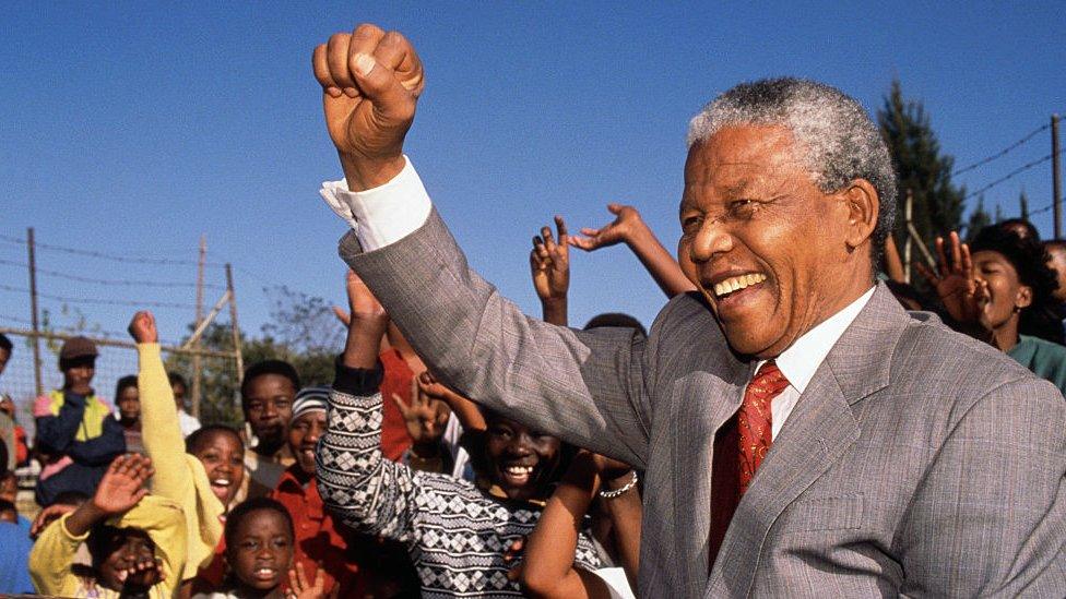 Nelson Mandela holding his fist up