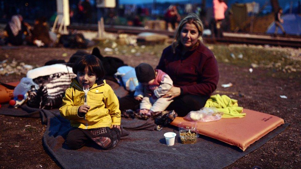 Refugee family prepares to sleep by railway tracks at makeshift camp by Greek-Macedonian border near Greek village of Idomeni. 1 March 2016