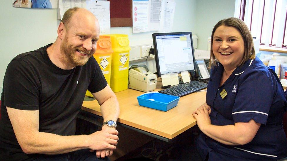 Aled Richards with a nurse sitting at a desk