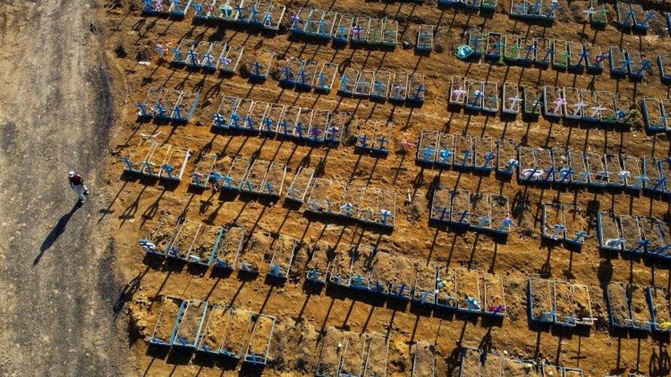 Aerial view showing a man walking past graves in the Nossa Senhora Aparecida cemetery in Manaus