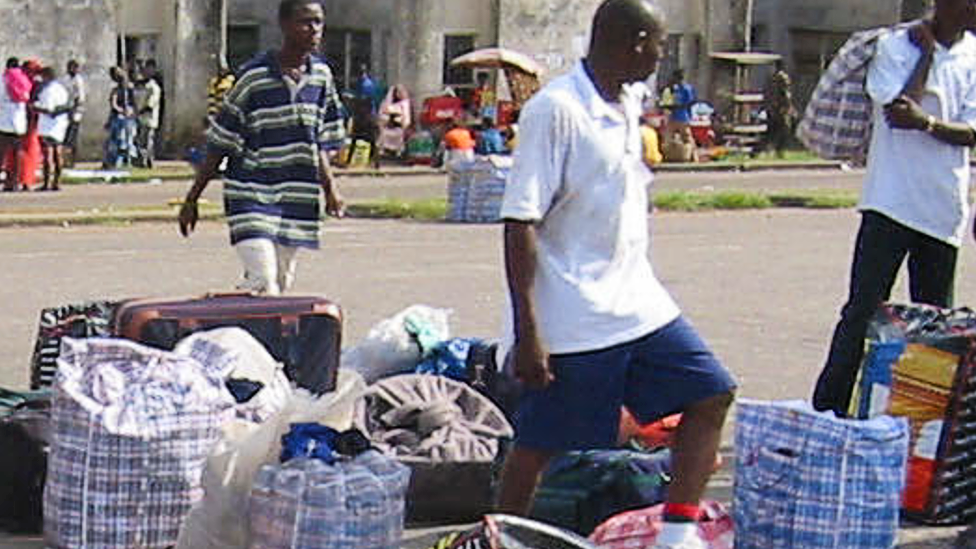 Nigerian returnees and Liberian refugees from war-torn Liberia identify their luggage in Lagos, Nigeria - 20 June 2003