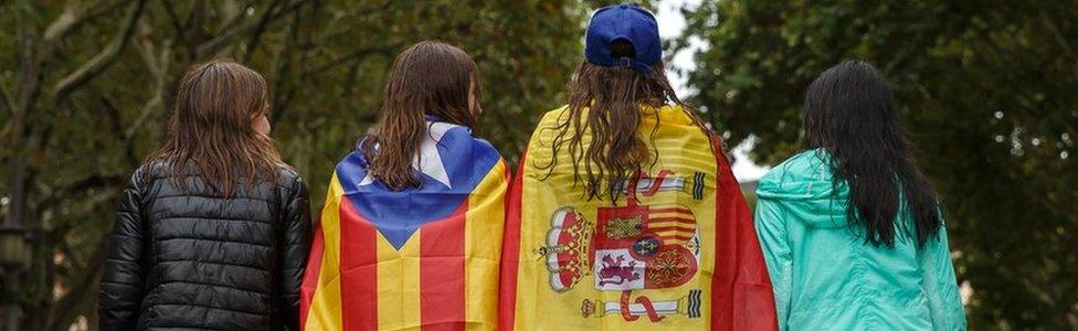 Girls stroll through the centre of Figueras with the Spanish and a pro-independence "Estelada" Catalan flag on 30 September 2017