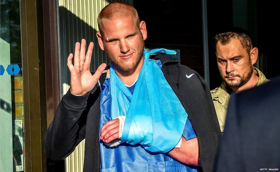 Spencer Stone waves as he leaves hospital in France.