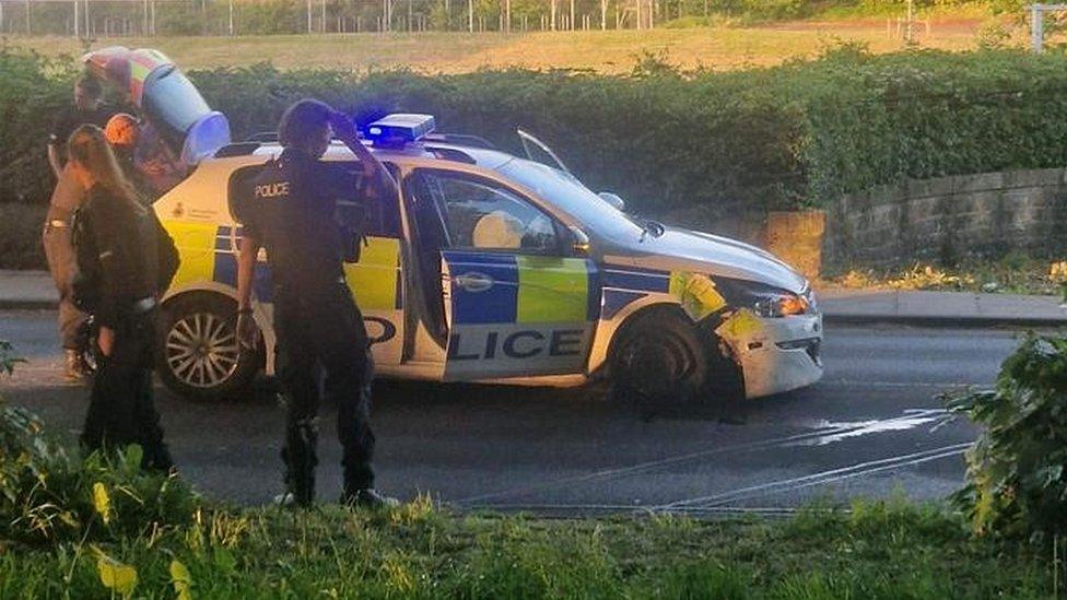 Police officers around car with damaged front wheel