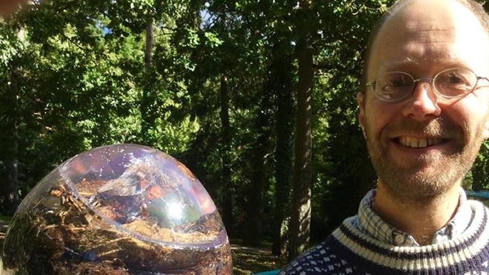 National-Poo-Museum-man-holds-up-poo-in-a-resin-ball.