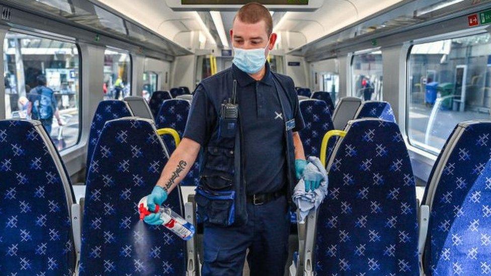 A railway worker cleans a carriage