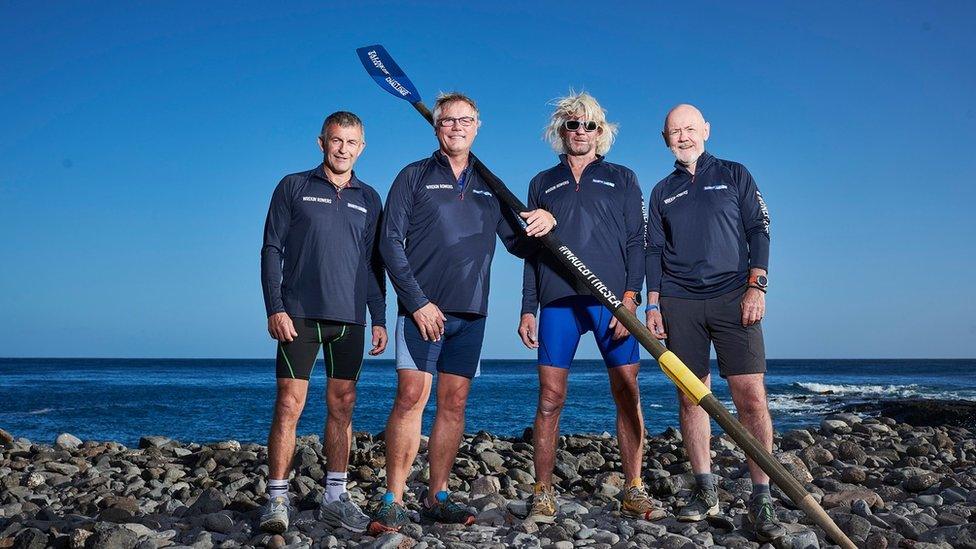 Four men standing on a beach