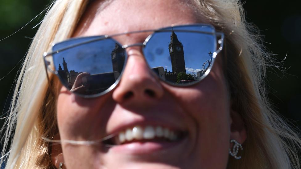 Houses of parliament reflected in woman's sunglasses