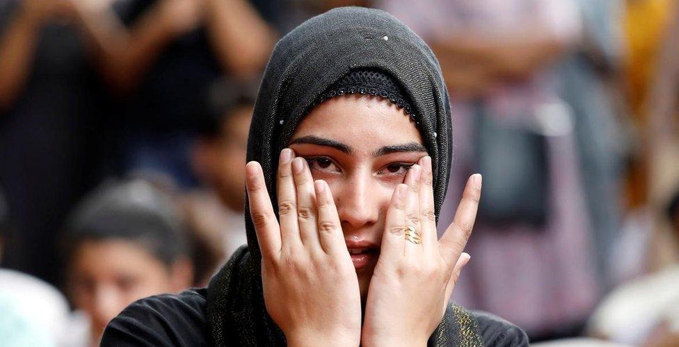 A Kashmiri woman wipes her tears while listening to a story of a Kashmiri man at a function in New Delhi where compatriots gathered to observe Eid.