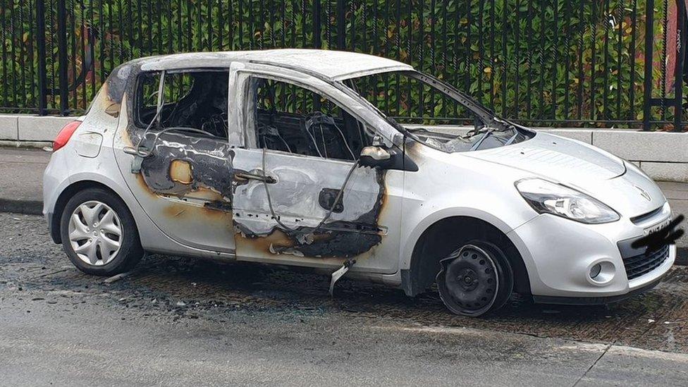 The burnt-out Renault Clio in Beechmount Avenue