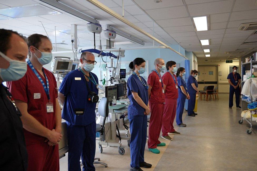 Nurses and firefighters stand alongside each other in an ICU ward