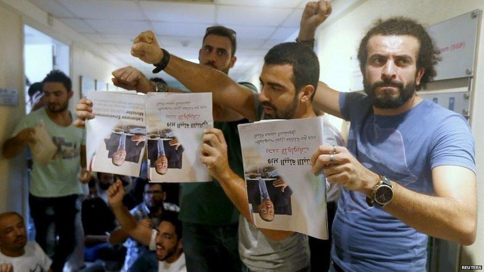 Protesters hold pictures of Environment Ministry Mohammad Machnouk upside down inside the ministry in Beirut. Photo: 1 September 2015