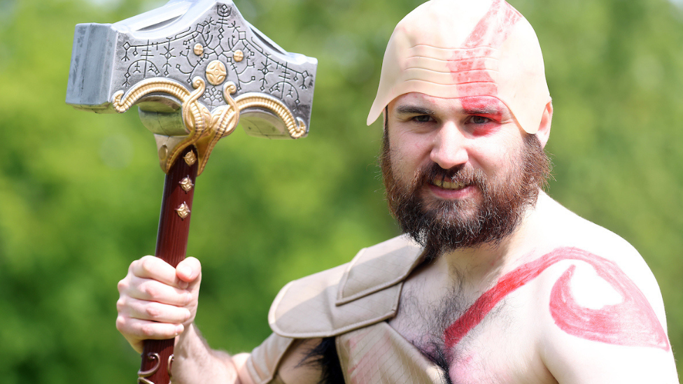 Man in costume holding hammer at QCon