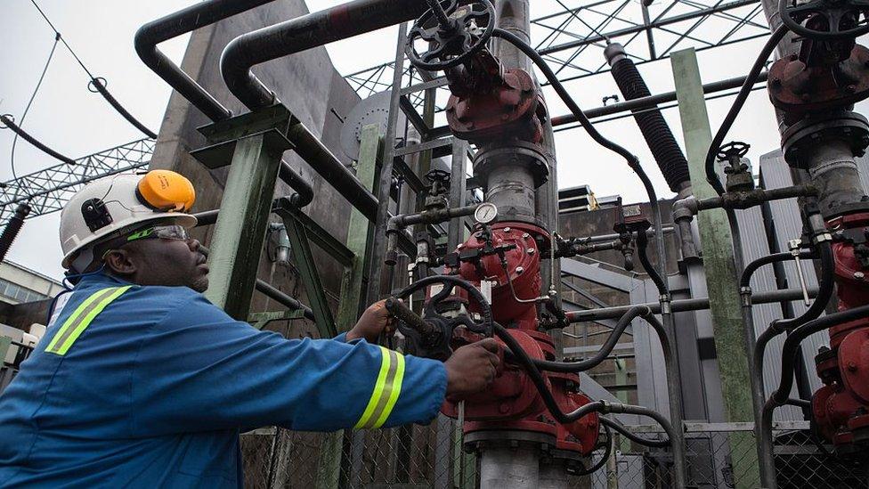 An employee of the Afam VI power plant adjusts a pipe at the plant in Port Harcourt