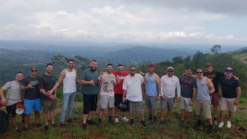 The group of 14 friends pose for a photo in the Costa Rican mountains