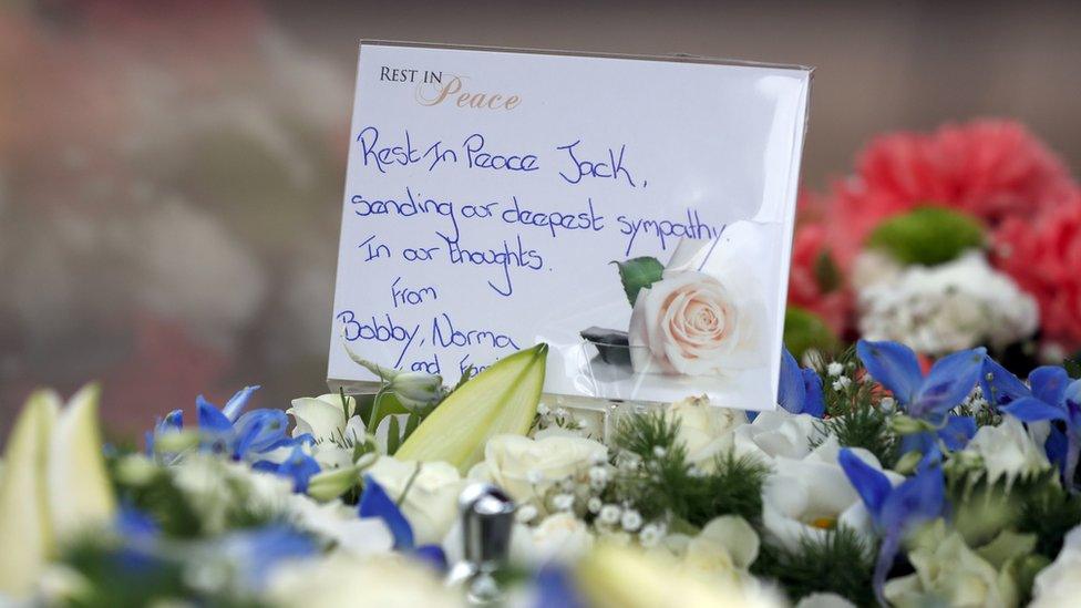 A floral tribute with a written message from Sir Bobby Charlton