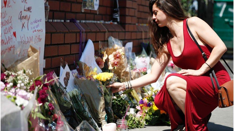 A woman laying flowers outside Finsbury Park Mosque