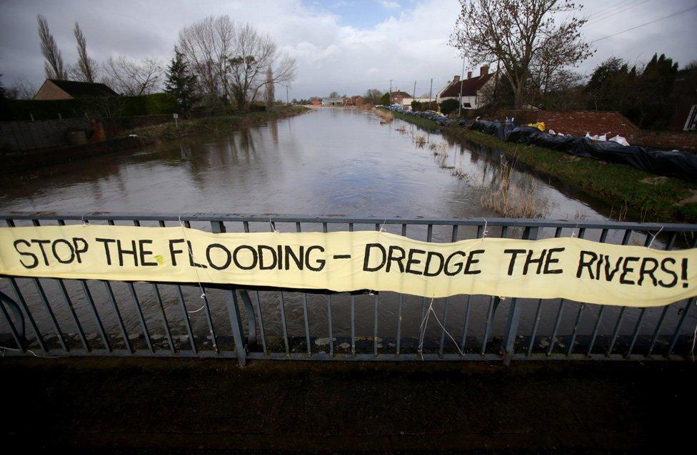 A protest banner is displayed on the road bridge crossing the River Parrett at Burrow Bridge in January 2014 in Somerset,