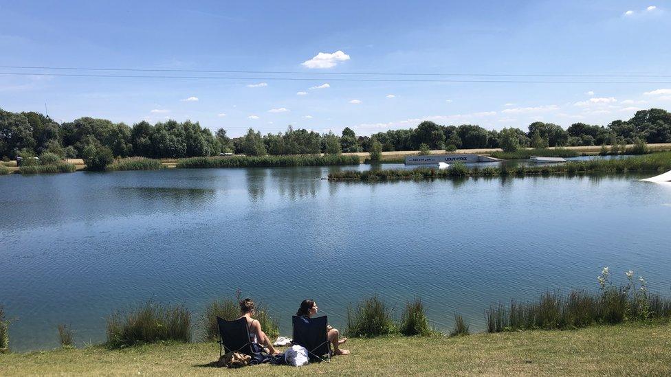 Two women in deckchairs overlooking water at Box End Park