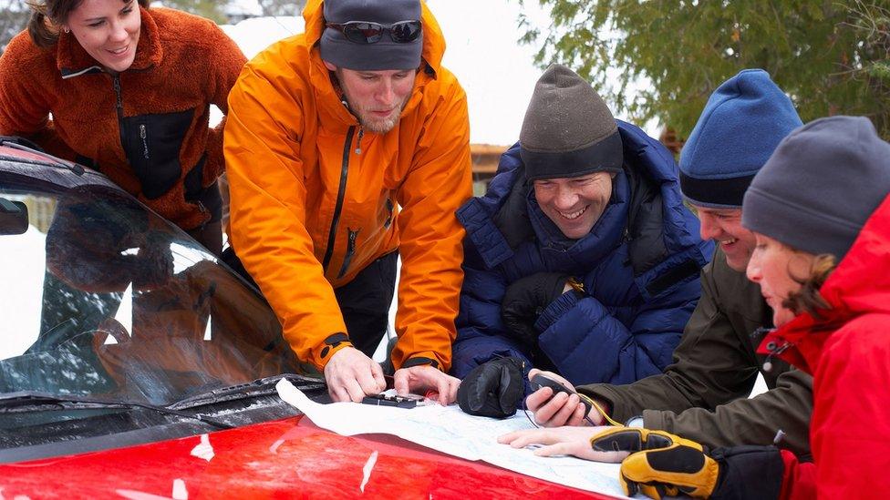 Walkers using GPS devices and maps