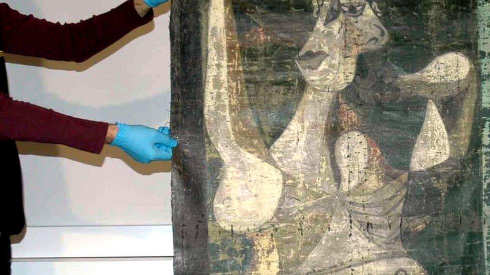 Police officers hold what is thought to be a Picasso painting in Istanbul, 30 January 2016