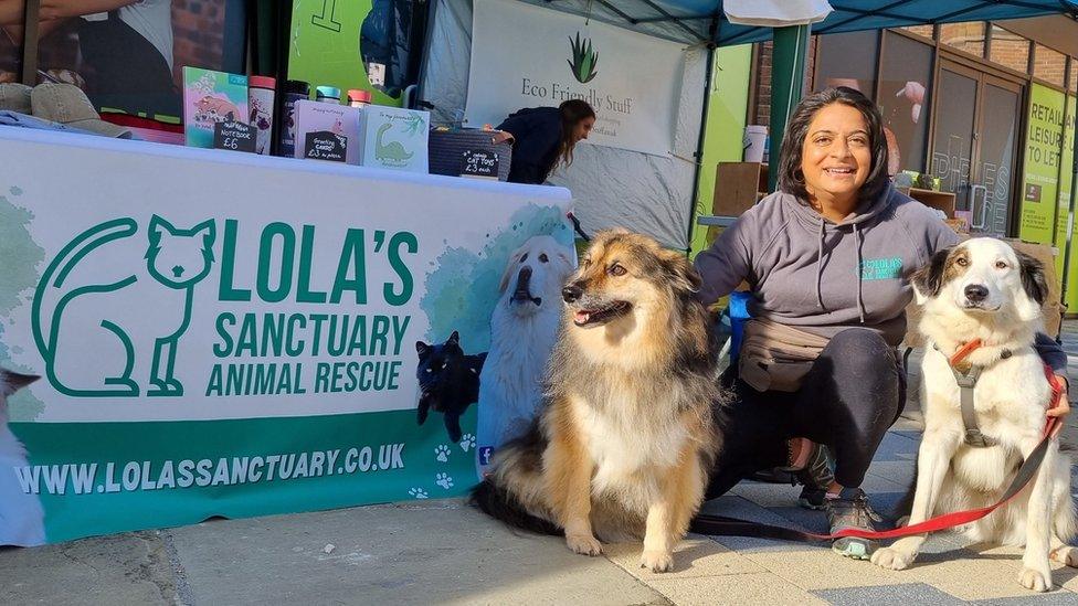 Poonam Doshi with two dogs by a charity stall