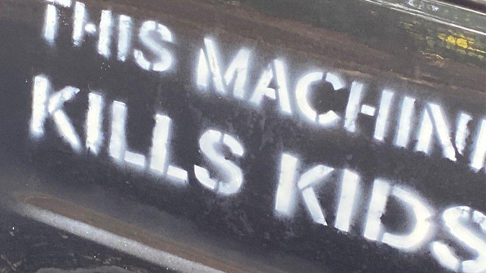 Car with 'this machine kills kids' written on the side