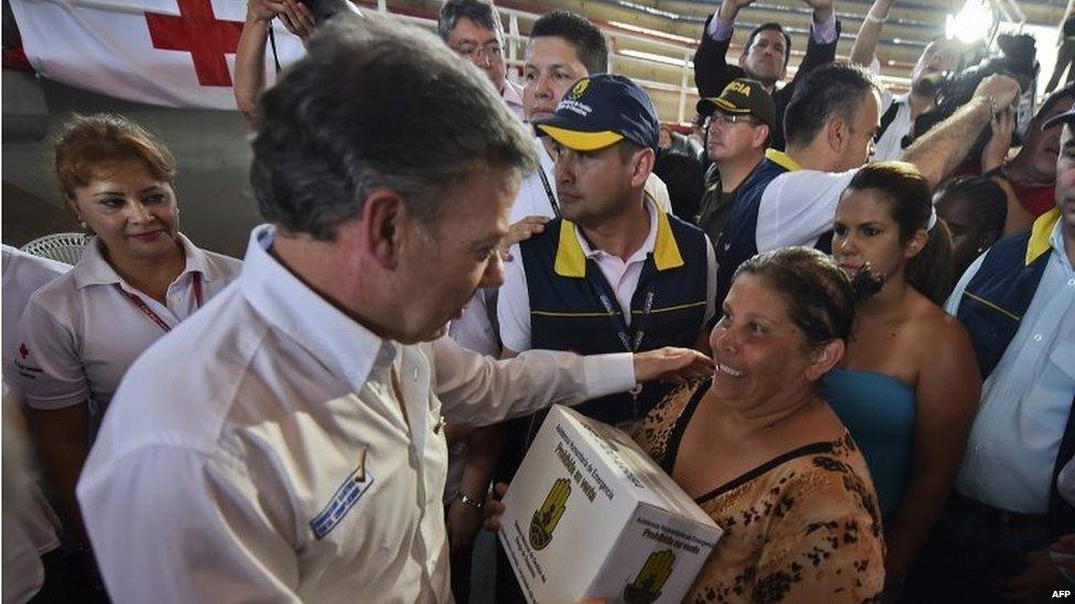 Colombian President Juan Manuel Santos (left) greets a woman as humanitarian aid is distributed at a shelter in Cucuta on 26 August 2015