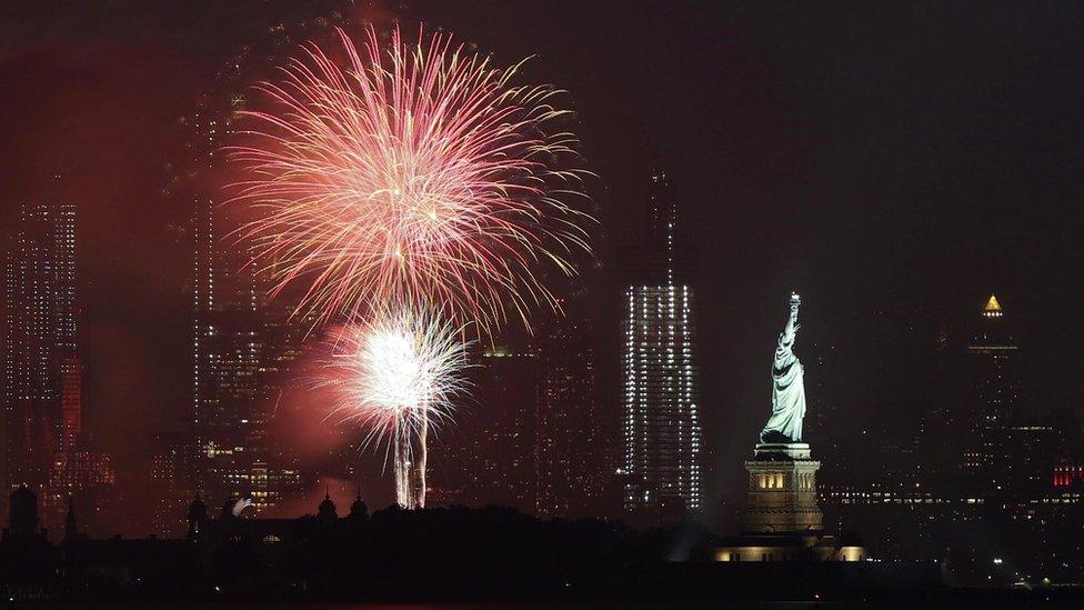 Fireworks pictured next to statue of liberty and New York skyline