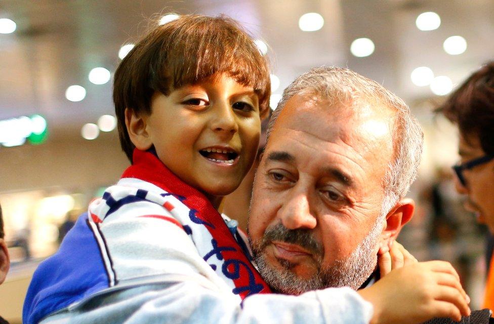 Syrian Osama Abdul Mohsen holds his son Zaid as they arrive at the Barcelona train station on Wednesday, Sept.16, 2015