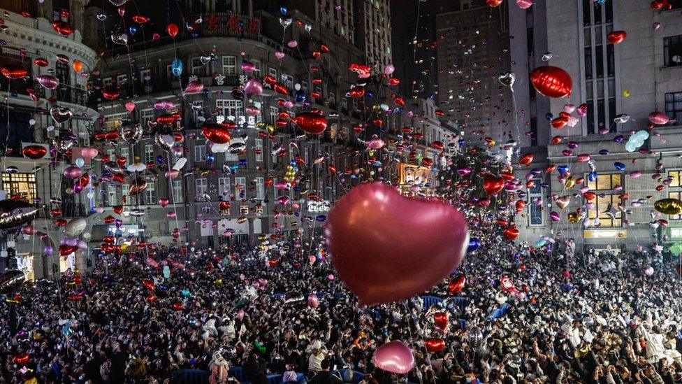 Revelers release balloons to celebrate the New Year on pedestrian street Jianghan Road on December 31, 2022 in Wuhan, China. (