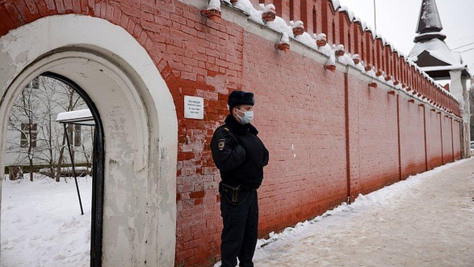 A police officer stands guard by an entrance to the Vvedenskiy Vladychniy convent