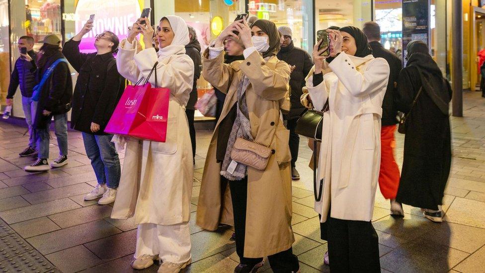 People take photos of the Ramadan lights in London