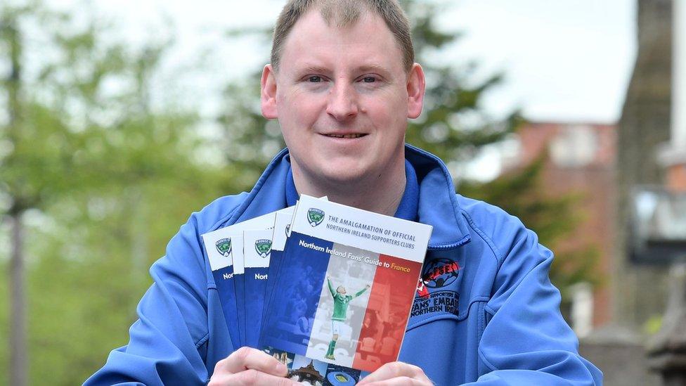 Gary McAllister from the Amalgamation of Official NI Supporters' Clubs with a copy of the fans' guide for the Euro 2016 finals