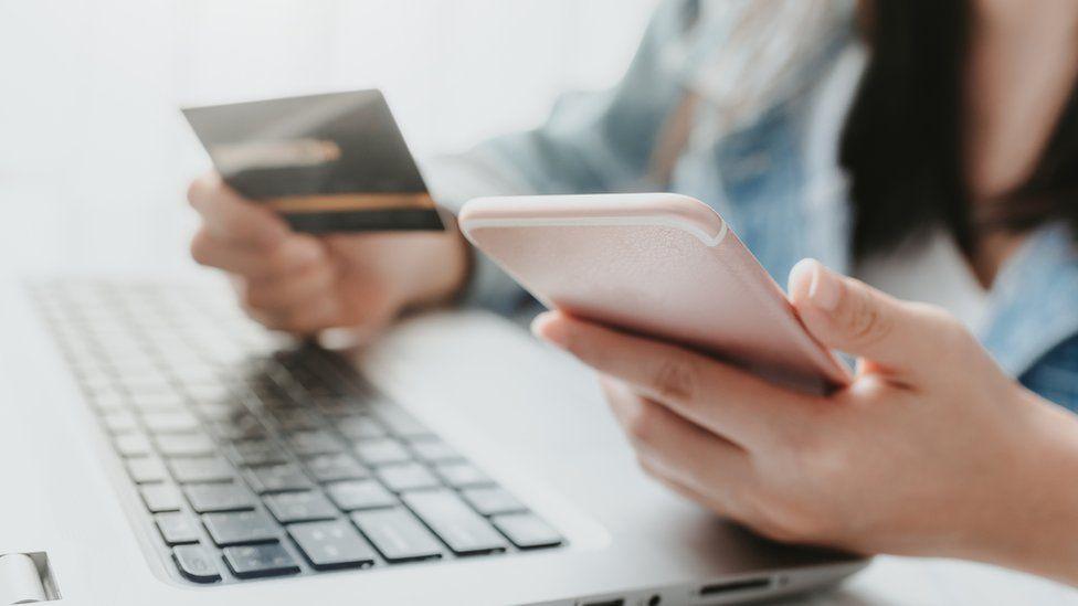 Person holding bank card and phone