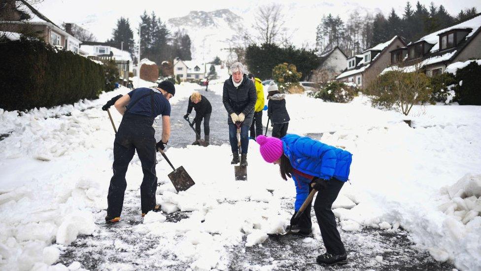 People shovelling snow