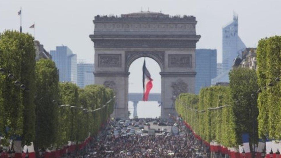 People walk on the Champs Elysees in Paris (08 May 2016)