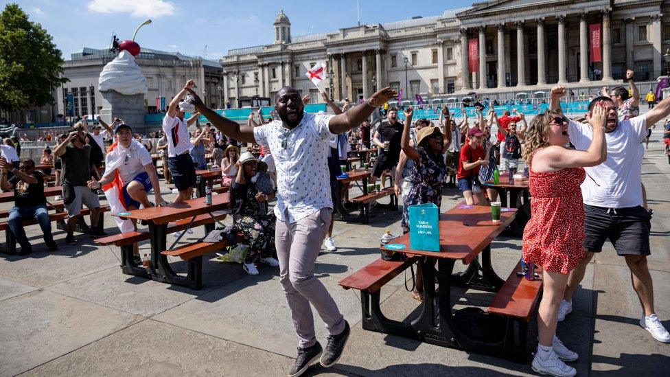 Football fans at a fan zone in Trafalgar Square celebrate as England score in their opening game against Croatia