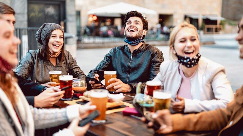 People drinking beer outside a bar