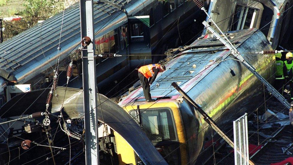 Investigators inspect the wreck of an overturned passenger train