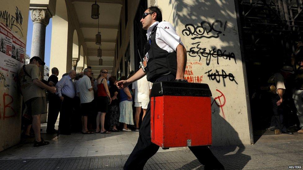 A security worker carries money outside a National Bank branch in the city of Thessaloniki, Greece (9 July 2015)