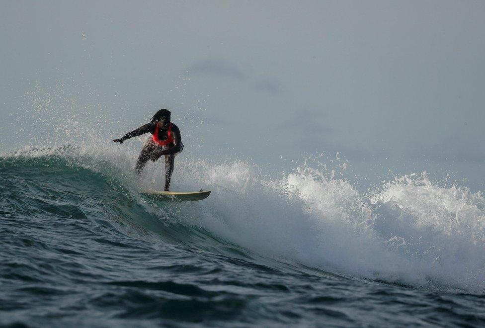 Khadjou Sambe surfs in the ocean