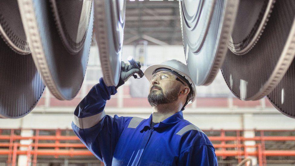 An engineer inspects a turbine in a nuclear power station.